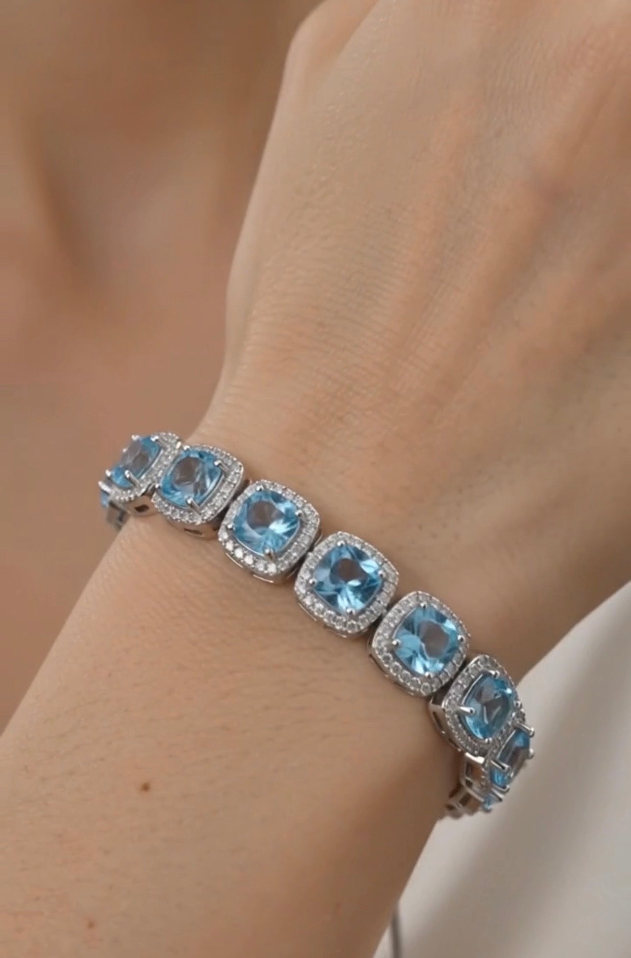 Dettaglio bracciale in argento 925 con topazi azzurri taglio cushion e micro pavé di zirconi bianchi