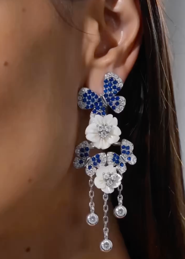 Orecchini lunghi fiori madreperla e zirconi blu indossati, gioielli artigianali made in Italy