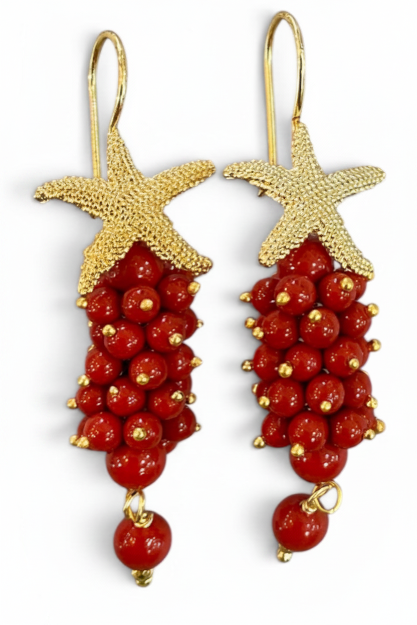 Orecchini stella corallo rosso angolatura 3/4 – dettaglio cluster e charm stella dorata, I Gioielli del Mare
